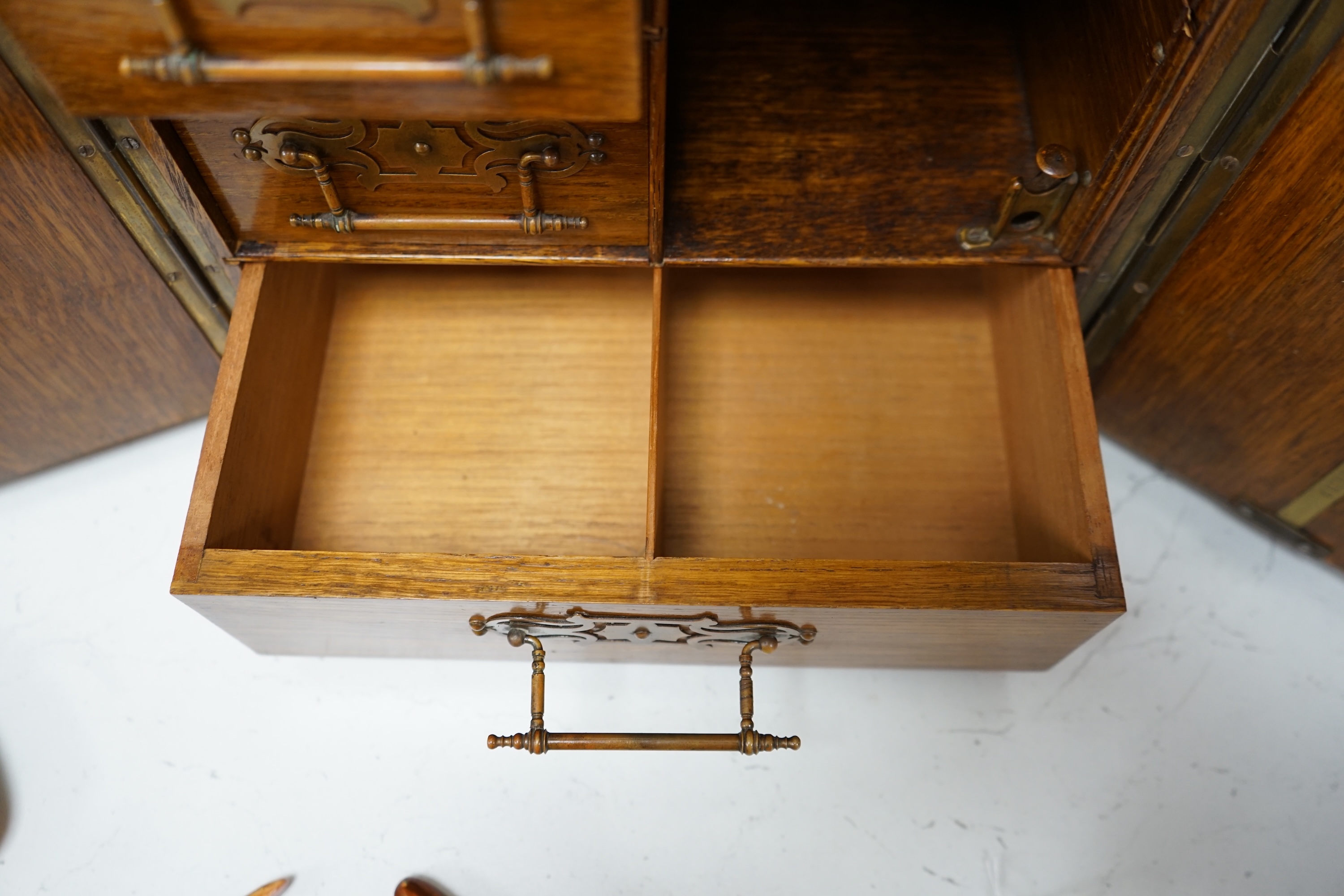 A Victorian oak cigar cabinet modelled as a safe, with brass coat of arms mounts, 30cm wide, 31cm high. Condition - fair